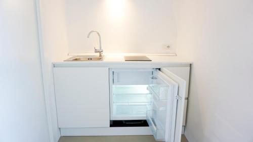 een keuken met een wastafel en een open koelkast bij Il Gabbiano Suites in San Marco di Castellabate