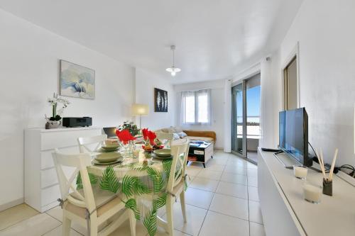 une salle à manger et un salon avec une table et une télévision dans l'établissement Eden Blue Wilson - Appt climatisé proche plage, à Juan-les-Pins