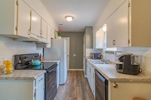 a kitchen with white cabinets and a white refrigerator at Charming Conway Getaway in Conway