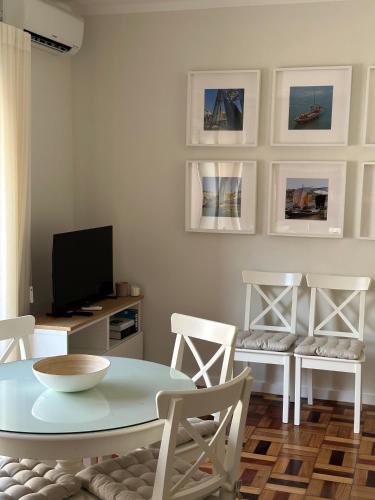 a living room with a table and chairs and a television at 115 OPorto Guest House in Porto