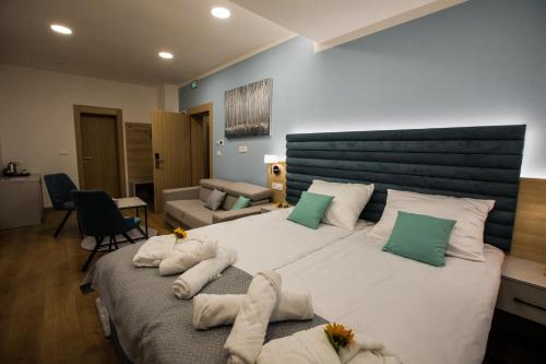 a bedroom with a large bed with green and white pillows at Klečka vila (apartment) with Hot tub & Sauna in Ogulin