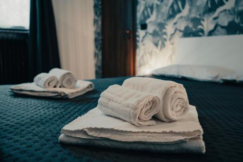 2 gerollte Handtücher auf einem Bett in einem Hotelzimmer in der Unterkunft Design & Giardino con Sauna & Hammam - Free WiFi in Margarita