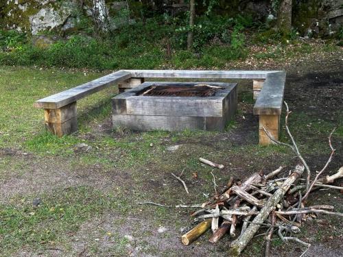 um banco de madeira sentado ao lado de uma pilha de troncos em Bastu hus 3km sandstrand klubbhus och disco em Värnamo