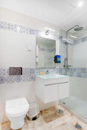 a bathroom with a toilet and a sink and a tub at Hotel Carvoeiro Plaza in Carvoeiro