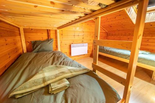 a bedroom with two bunk beds in a log cabin at Le Chant du Ruisseau SPA - Sauna in Le Tholy