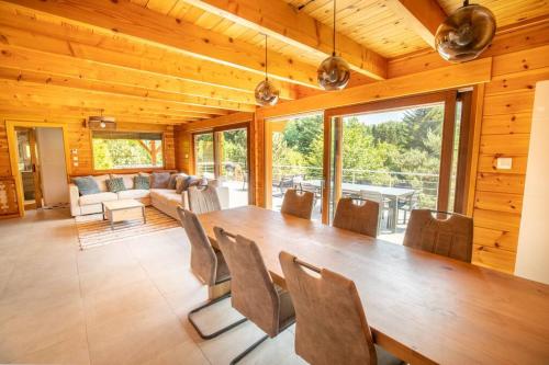 a dining room with a large wooden table and chairs at Le Chant du Ruisseau SPA - Sauna in Le Tholy