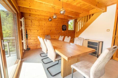 a dining room with a wooden table and chairs at Le Chant du Ruisseau SPA - Sauna in Le Tholy