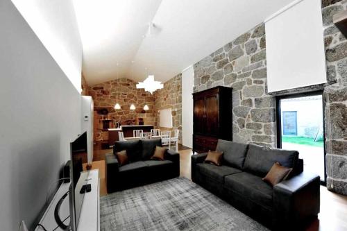 a living room with a couch and a stone wall at Casas do Ermo - Ermo Villas in Fafe