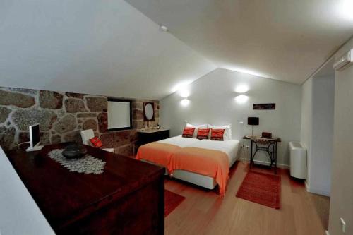 - une chambre avec un lit et un mur en pierre dans l'établissement Casas do Ermo Ermo Villas, à Fafe