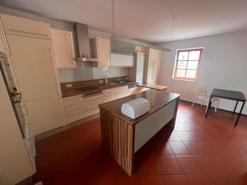 a kitchen with white cabinets and a brown tile floor at Monteurzimmer Linz in Linz