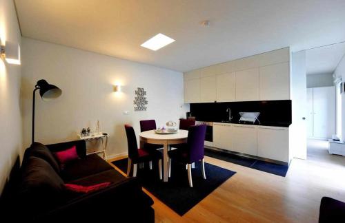 a living room with a couch and a table and a kitchen at Casas do Ermo - Ermo Villas in Fafe