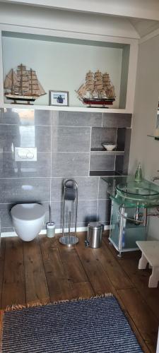 a bathroom with a white toilet and a glass sink at Cottage 2 meters from the sea, Bekkjarvik, 60 km from Bergen 