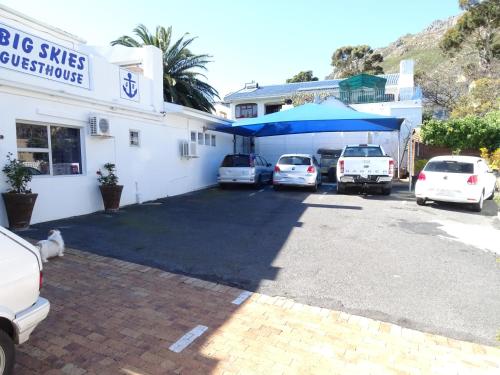 um parque de estacionamento com carros estacionados em frente a um edifício em Big Skies Guesthouse em Gordonʼs Bay