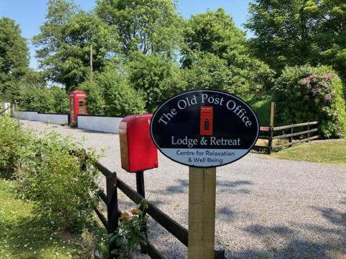 a sign for the old post office with two red phone booths at The Old Post Office Lodge in Enniskillen
