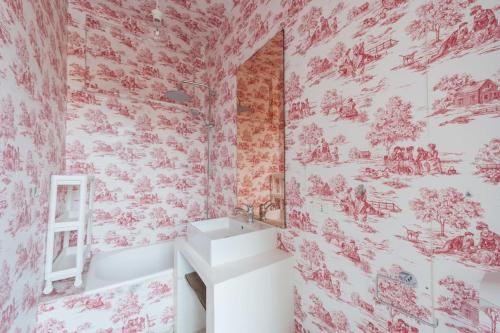 baño con lavabo blanco y papel pintado de color rojo en Modern, contemporary flat-15 minutes to Venice, en Mestre