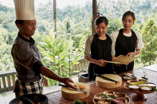a group of people standing around a table with food at Bagus Jati Health & Wellbeing Retreat in Tegalalang