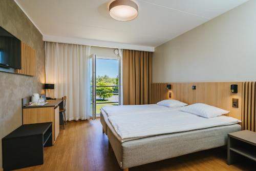 a bedroom with a large bed and a large window at Hestia Hotel Strand in Pärnu