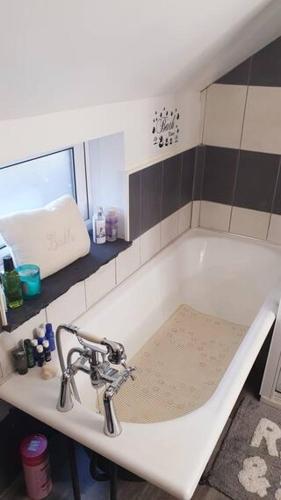 a bathroom with a bath tub with a sink at The Old Post Office Lodge in Enniskillen