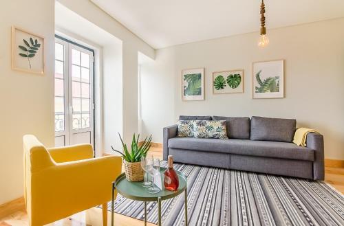 uma sala de estar com um sofá e uma mesa em Santos Green Apartment em Lisboa