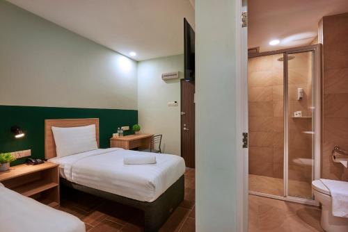 a hotel room with a bed and a shower at ZONE Hotels, Eco Grandeur in Bandar Puncak Alam