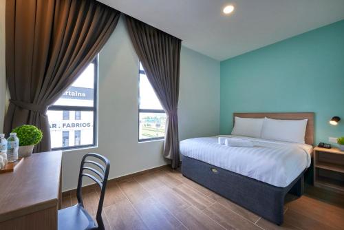 a bedroom with a bed and a desk and a window at ZONE Hotels, Eco Grandeur in Bandar Puncak Alam
