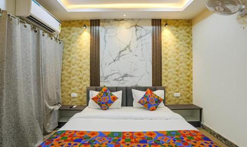 a bedroom with a large bed with colorful pillows at FabExpress Namaste Kashi in Varanasi