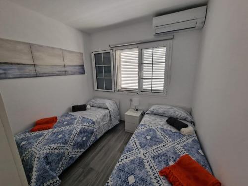 a bedroom with two beds and a window at Chalet con 3 camere e giardino in Maspalomas