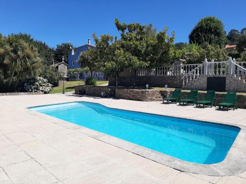 una piscina con sedie e una casa di As Seis Chemineas a San Xulián de Sales