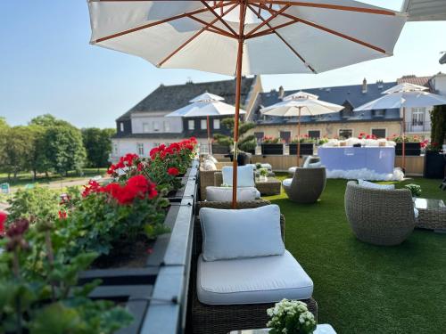 - une terrasse avec des chaises, un parasol et des fleurs dans l'établissement Best Western Plus Thionville Centre, à Thionville