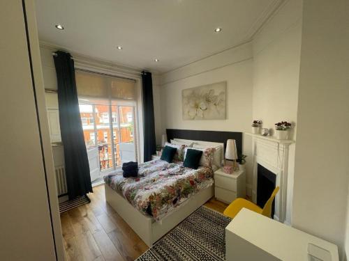 ein Schlafzimmer mit einem Bett und einem Kamin in der Unterkunft HYDE PARK, OXFORD STREET, PADDINGTON, BEAUTIFUL 3 BEDROOMS,BALCONY, 2 BATH, MANSION BLOCK, MAIDA VALE, W9 NW8 LORDs CRICKET in London