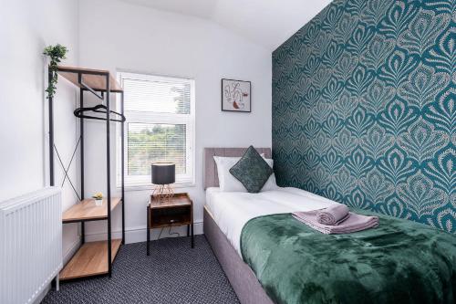 a bedroom with a bed with a green bedspread at Stylish Home with Garden, Free Street Parking in Hull