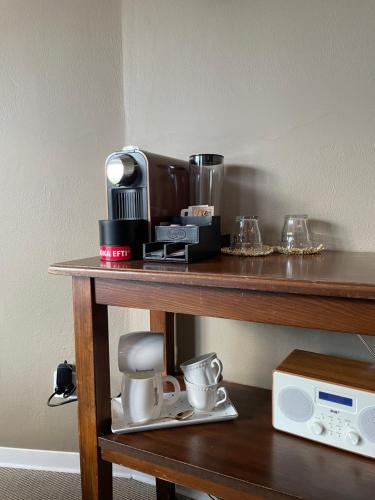 a table with a coffee maker and cups on it at Boutique Centrale in Brione sopra Minusio