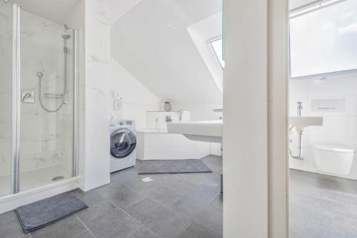 a white bathroom with a sink and a washing machine at Waidla-Studio in Freyung