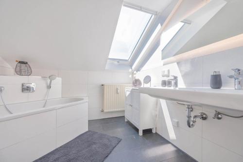 uma casa de banho branca com um lavatório e uma banheira em Waidla-Studio em Freyung