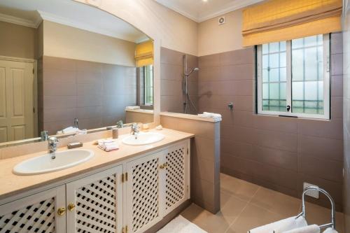 un bagno con due lavandini e un grande specchio di Sera - Luxury 3 bedroom apartment with pool, golf,beach a Ludo