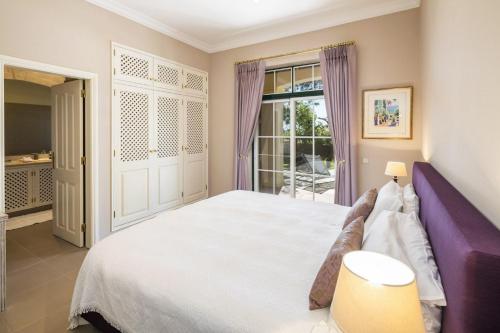 una camera con un grande letto e una finestra di Sera - Luxury 3 bedroom apartment with pool, golf,beach a Ludo
