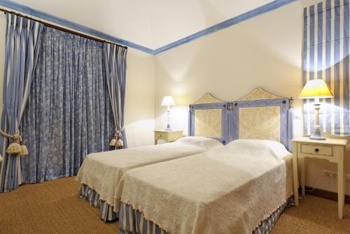 una camera d'albergo con due letti e tende di Tulio 2 Bedroom Luxury Apartment located in Encosta Do Lago a Quinta do Lago