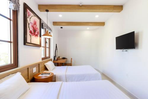 ein Hotelzimmer mit 2 Betten und einem Flachbild-TV in der Unterkunft EMOLIA Coffee-Tea & Mini Hotel in Phu Quoc