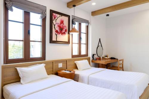 2 Betten in einem Zimmer mit 2 Fenstern in der Unterkunft EMOLIA Coffee-Tea & Mini Hotel in Phu Quoc