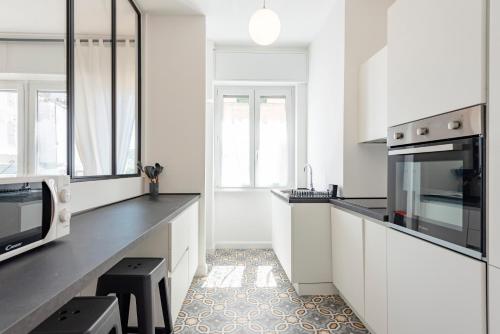 eine Küche mit weißen Schränken und einer Mikrowelle in der Unterkunft JOIVY Beautiful family flat with a Sea View in Rapallo
