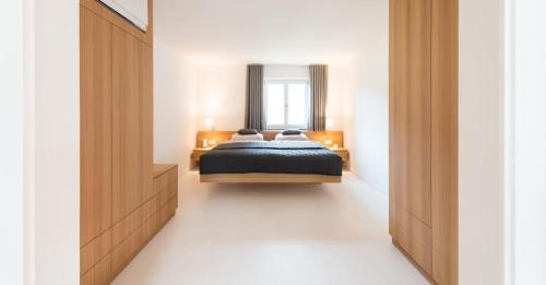 1 dormitorio con cama y espejo en luxuriöse Ferienwohnung in Mittenwald für Genießer en Mittenwald