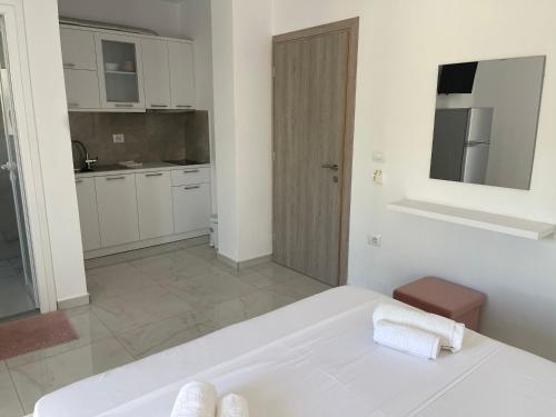a white bedroom with a bed and a kitchen at Villa Angelina Ksamil in Ksamil