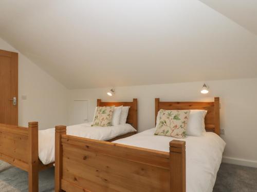 two twin beds in a room with white walls at Swallows Lodge in Edenbridge