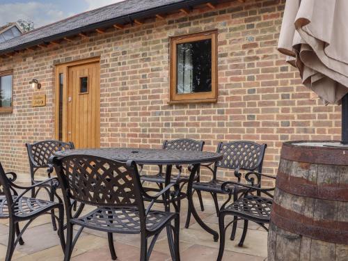 a table and chairs in front of a brick building at Swallows Lodge in Edenbridge