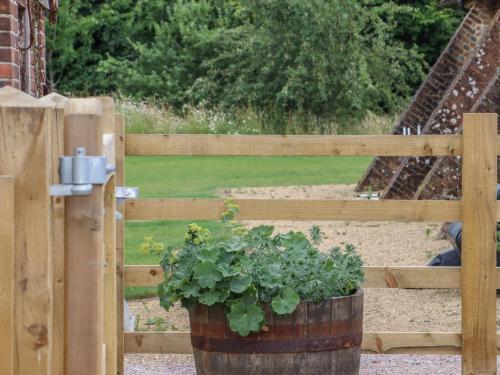 a wooden fence with a plant in a barrel at Swallows Lodge in Edenbridge