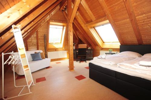Dormitorio en el ático con cama y escalera en Casa Cara en Baiersbronn
