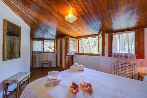 a bedroom with a large bed with a wooden ceiling at Il Rododendro City Center - Happy Rentals in Bardonecchia