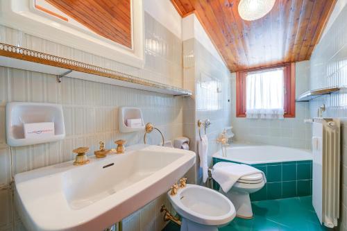 a bathroom with a sink and a toilet and a tub at Il Rododendro City Center - Happy Rentals in Bardonecchia