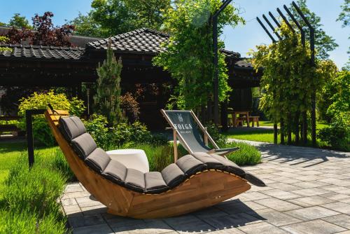 einem Holzstuhl, der mitten im Hof sitzt in der Unterkunft FOLGA - Hotel, Restauracja, Browar, SPA in Gryfice