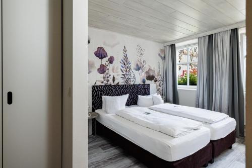 a bedroom with two beds and a window at Flair Hotel zum Storchen in Bad Windsheim
